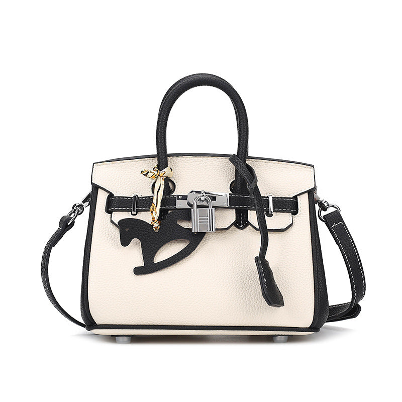 Front view of a bi-color White and Black inspired Birkin handbag in premium top grain leather, featuring a silver padlock, double rolled handles, and a black horse charm.