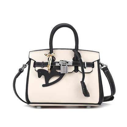 Front view of a bi-color White and Black inspired Birkin handbag in premium top grain leather, featuring a silver padlock, double rolled handles, and a black horse charm.