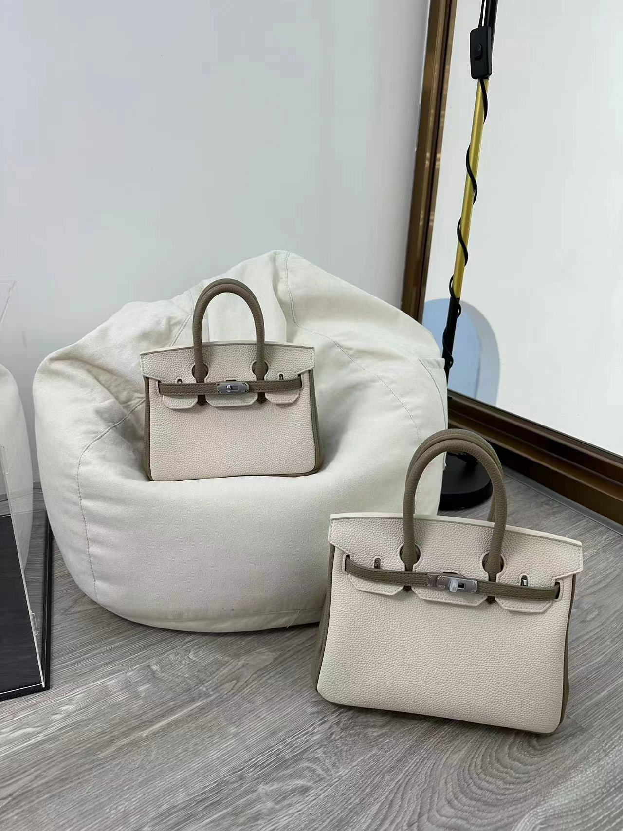 Lifestyle shot of a model wearing a bi-color White and Black inspired Birkin handbag in top grain leather, styled as a chic crossbody bag with silver hardware for a modern look.