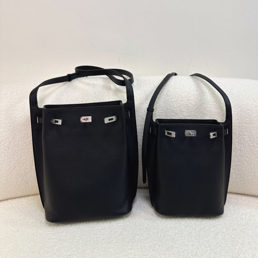 Two black pebbled top-grain leather Kelly-inspired bucket bags in mini and small sizes with silver turn-lock hardware.