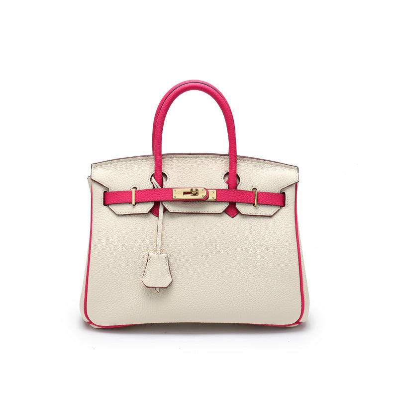 A top grain leather handbag with a classic design, featuring a gold-tone twist lock and double rolled handles. 