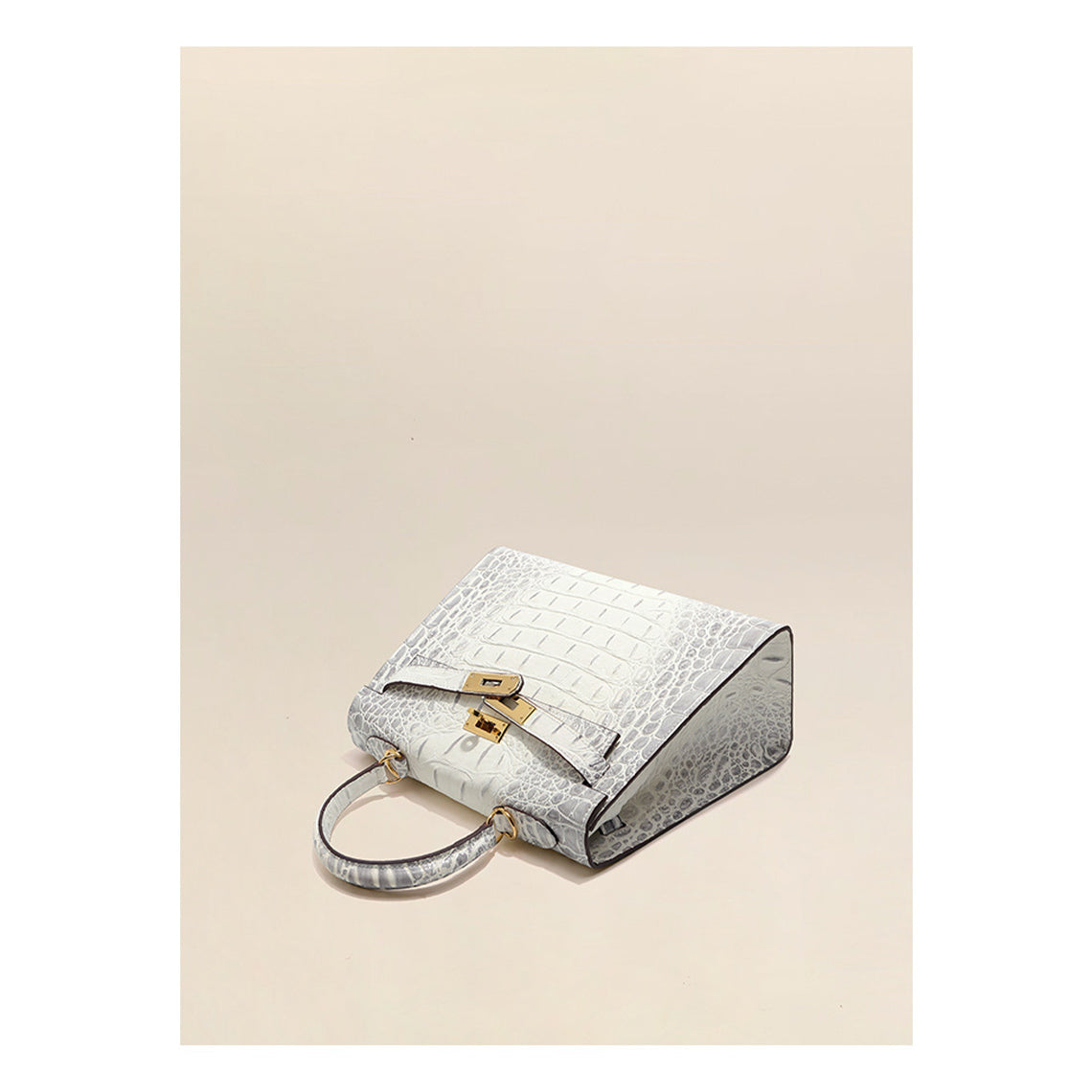 Top-down view of a Himalayan White croc-embossed Kelly bag, highlighting its trapezoid shape and gold hardware.