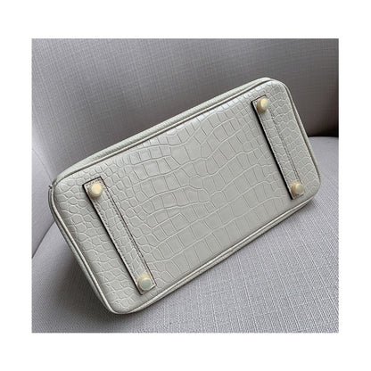 Bottom view of a white Croc Flap Berkin Bag showcasing the crocodile embossed leather base and four protective gold-tone metal feet.