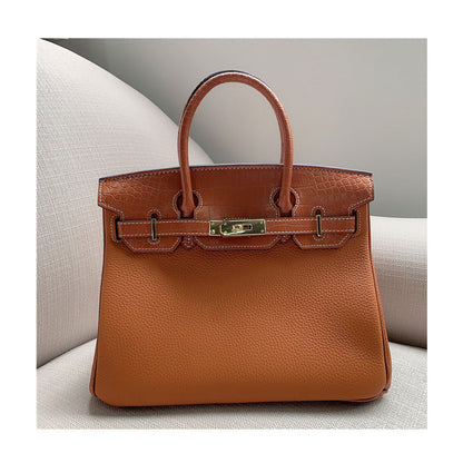 Front view of a tan Croc Flap Berkin Bag showcasing the contrast between the pebbled Togo top grain leather body and the crocodile embossed leather flap, featuring polished gold-tone hardware.