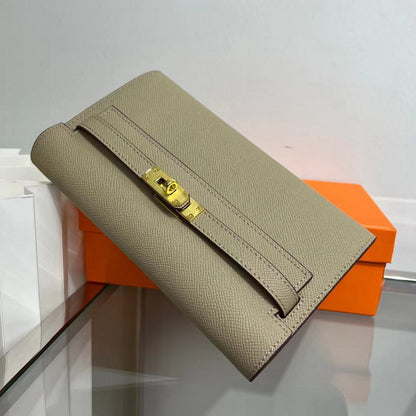 Angled view of an Apricot Grey inspired Kelly to go wallet in textured cowhide leather, highlighting the elegant golden Kelly closure and fine Epsom-style grain.