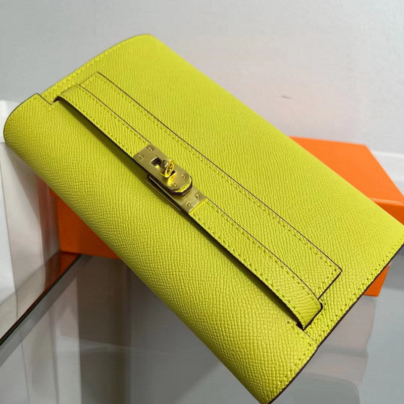 Angled view of a vibrant Yellow inspired Kelly to go wallet in textured cowhide leather, featuring the signature golden Kelly closure and elegant Epsom-style grain.