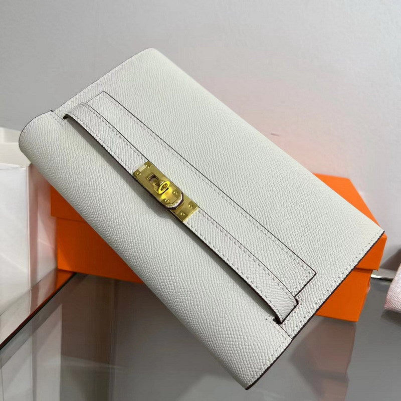 Angled view of a Milkshake White inspired Kelly to go wallet in textured cowhide leather, featuring the iconic golden Kelly closure and signature orange packaging.