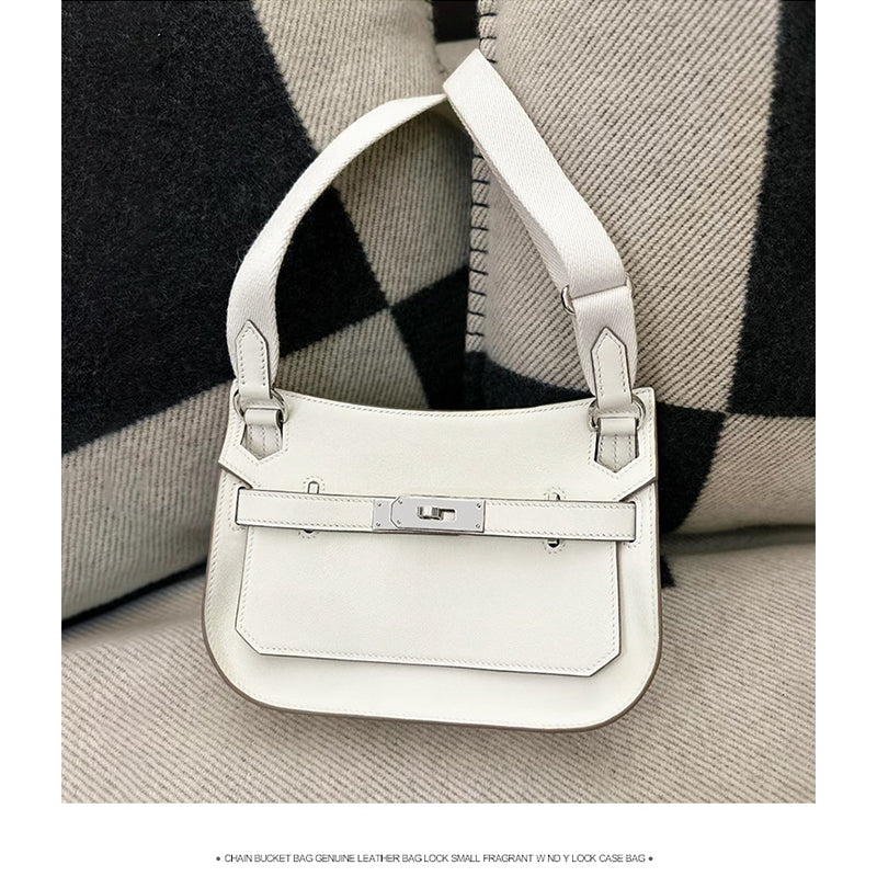 A crisp white leather Gypsy shoulder bag with silver-tone hardware and matching white stitching, presented against a patterned background for a clean, minimalist aesthetic.