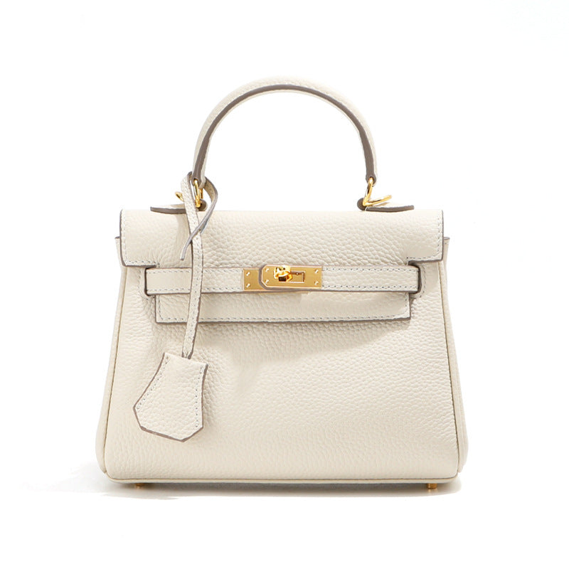 Front view of a white mini Kelli handbag in top grain leather with gold hardware.