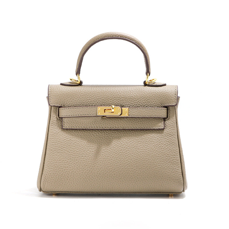 Front view of a taupe mini Kelli handbag in premium top grain leather with gold hardware.
